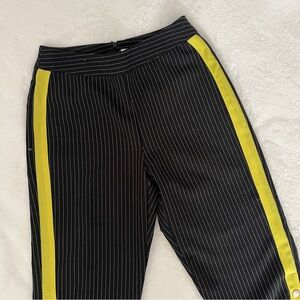 Black pinstripe pants with yellow/green stripe on side and snaps